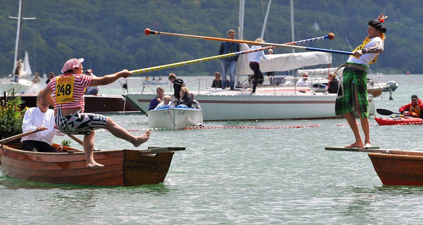 2012年7月22日，德国施塔恩贝格，一名渔民格斗选手在比赛期间落入湖中。渔民格斗赛的目标是将对手用尖部被包裹起来的杆子推入水中。 CFP_财新每周图片(2012.7.21-7.27)