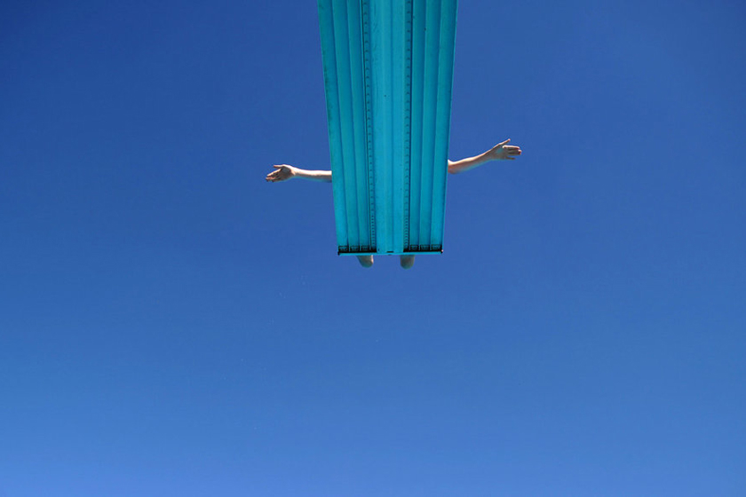 2012年7月24日，德国汉诺威，一个男孩准备从甲板上跳入泳池。 JULIAN STRATENSCHULTE/东方IC_财新每周图片(2012.7.21-7.27)