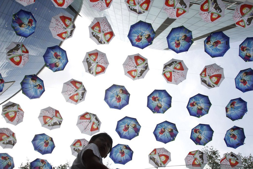 2012年7月25日，韩国首尔，一家商店在街头挂起一排排的雨伞以进行促销。 Ahn Young-joon/东方IC_财新每周图片(2012.7.21-7.27)