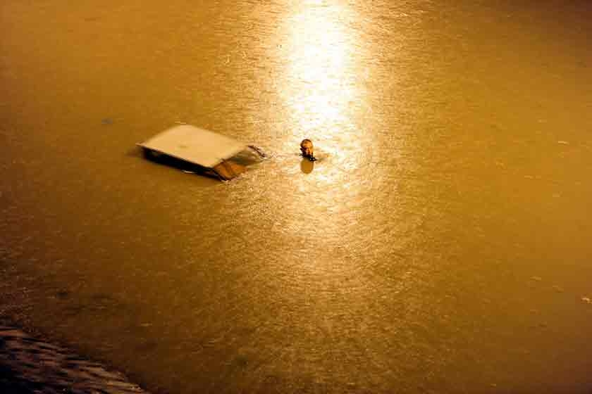 2012年7月21日，北京遭遇特大暴雨，朝阳区姚家园路的铁路桥被淹。一名电动车司机试图推车涉水过桥洞。 东方IC_北京逝者