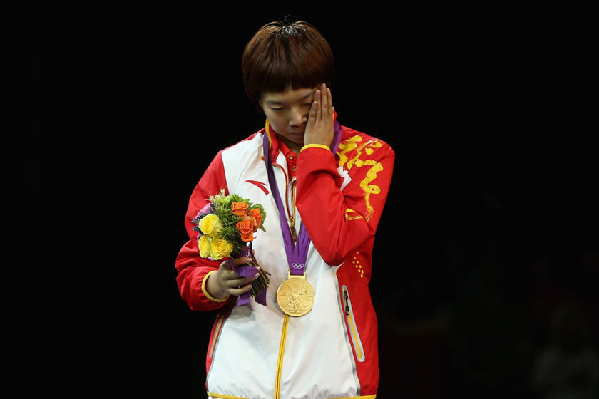 在中国优势项目乒乓球女子单打决赛开始前，中国已提前包揽冠亚军。最终，李晓霞以4-1的比分战胜队友丁宁，首夺奥运金牌。获胜后的她泪洒颁奖台。 Feng Li/Getty Images/CFP_奥运人物【第4期】