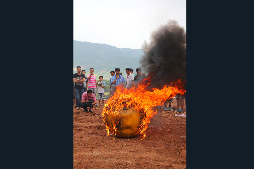 8月6日，燃烧实验：工作人员拿出一个直径50厘米左右的缩小版“诺亚方舟”，浇上2桶汽油，并往舱室内装进大量冰棍。  东方IC_义乌商人150万造“诺亚方舟”