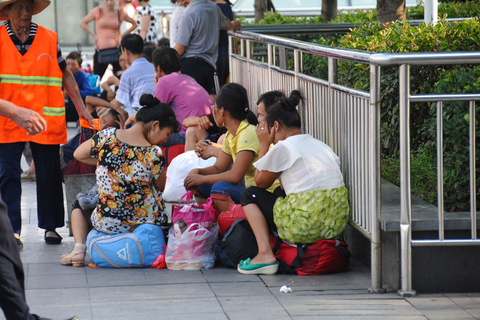 8月16日，等车的旅客依着栅栏席地而坐。 龙夫子/东方IC
