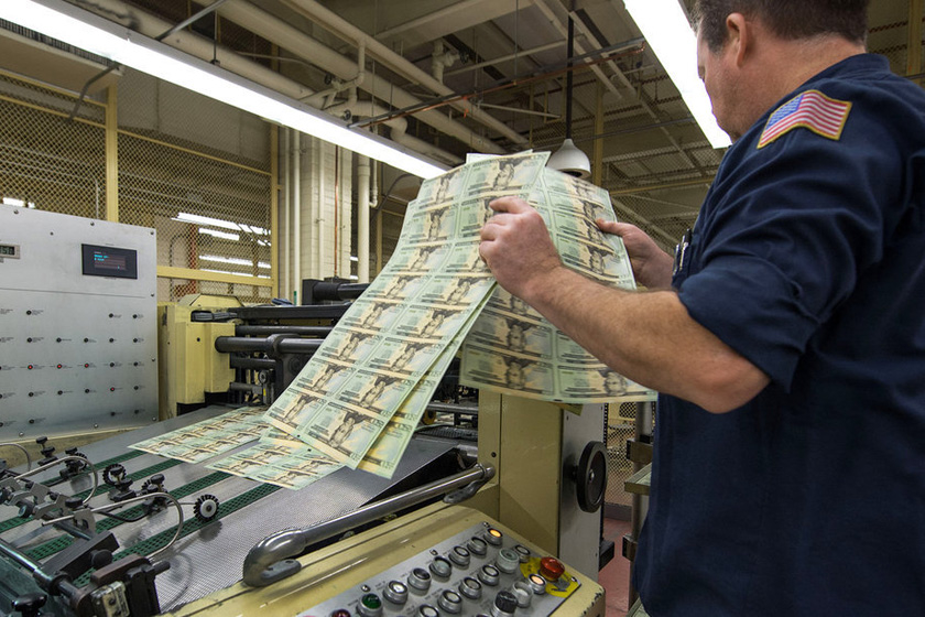 7月12日，美国华盛顿，工作人员正在裁剪机旁检验漏裁的纸钞。   东方IC_探秘美元生产过程
