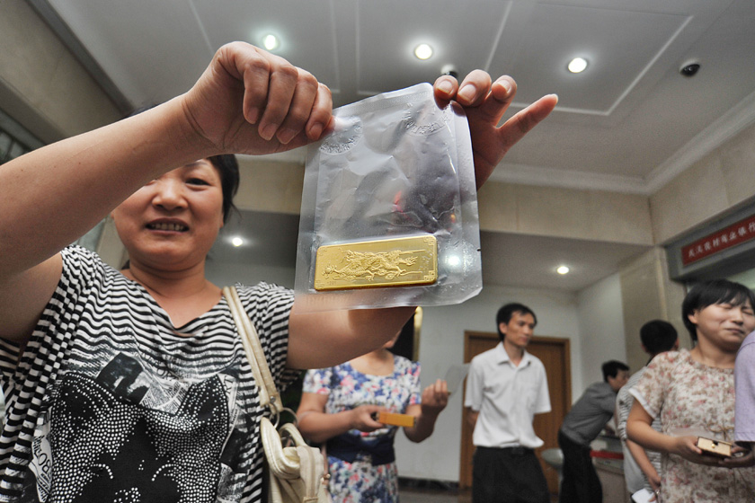 8月27日上午，武汉市青山区余家头村，村民喜滋滋地向记者展示刚领到的金条。  梅尔/东方IC _武汉“城中村”村民每人领百克黄金