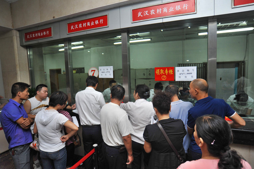 8月27日上午，武汉市青山区余家头村，银行柜台前挤满了前来领取金条的村民。  梅尔/东方IC _武汉“城中村”村民每人领百克黄金