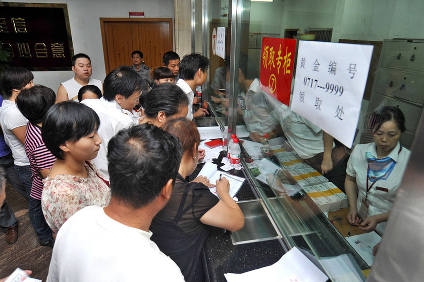 8月27日上午，武汉市青山区余家头村，银行柜台前挤满了前来领取金条的村民。  梅尔/东方IC _武汉“城中村”村民每人领百克黄金