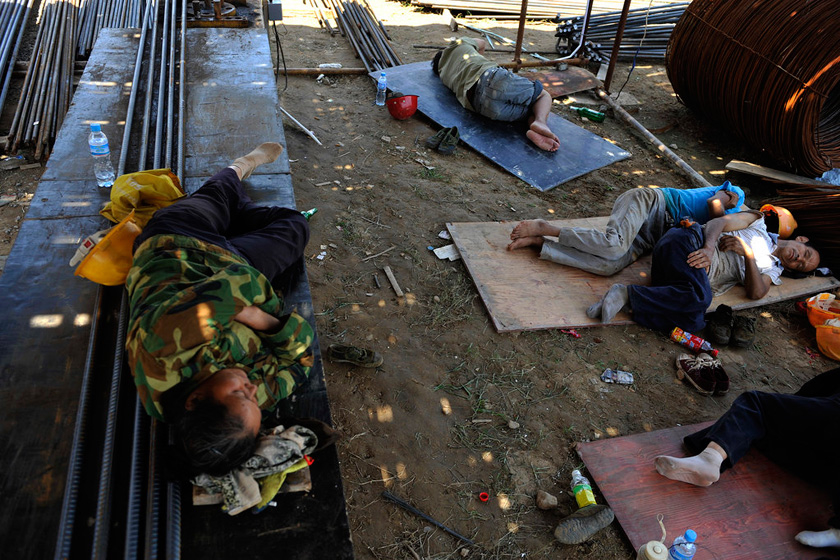 8月23日，郑州，天气炎热，许多农民工不愿意回到狭小的工棚，宁愿躺在工地午休。  华商报胡国庆/CFP_农民工夫妻生活现实