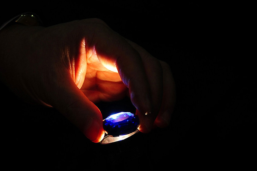 9月5日，科伦坡国际珠宝展会现场，一名参展人正在检查一颗蓝宝石。   东方IC_中国男子在国外珠宝展上吞下钻石被捕