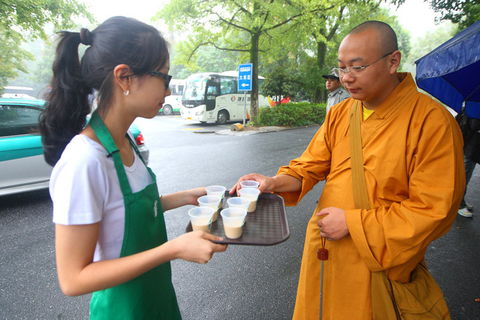 、9月22日，星巴克咖啡杭州灵隐寺门店开业，服务员把咖啡端给一名僧人品尝。   陈中秋/东方IC