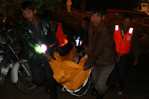 10月6日凌晨，救援人员将打捞到的一具遗体抬走。    郭国权/东方IC
