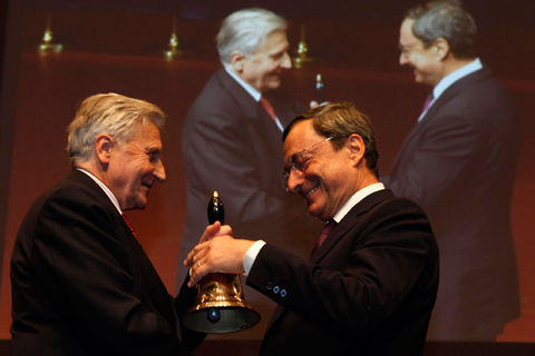 2011年10月19日，德国法兰克福，即将离任的欧洲央行行长特里谢（左）向其继任者、意大利央行行长德拉吉移交一个大铃铛。Ralph Orlowski/Getty Images/CFP