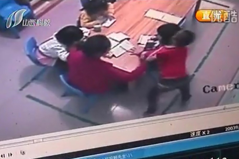 （截屏图）10月15日，监控录像显示，老师推搡一名男童。_太原五岁女童被幼儿园老师扇70耳光