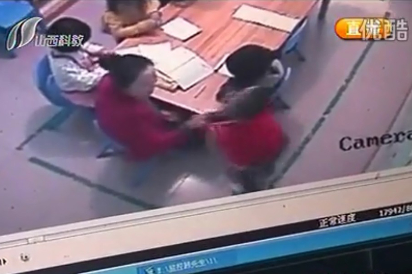 （截屏图）10月15日，监控录像显示，老师推搡一名男童。_太原五岁女童被幼儿园老师扇70耳光
