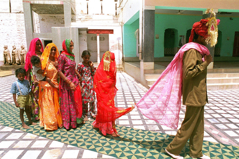 当地时间1998年4月22日，印度比卡内尔，8岁的Mina被22岁的新郎Sukhram牵着来到寺庙，身后是她的家人。    SAURABH DAS/东方IC_揭秘印度童婚陋习 娃娃新娘3岁出嫁