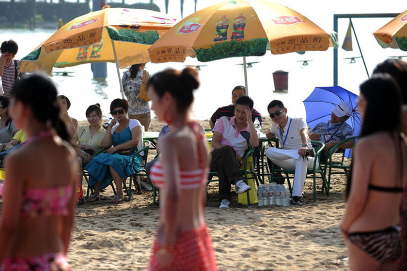 2011年6月25日，在武汉东湖沙滩浴场举行的财富英雄相亲会现场，女子身穿比基尼展示自己。    陈亮/CFP_“中国式”富豪相亲