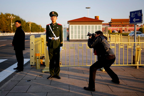 11月8日，北京，一位记者正在拍摄站岗的安保人员。  CFP