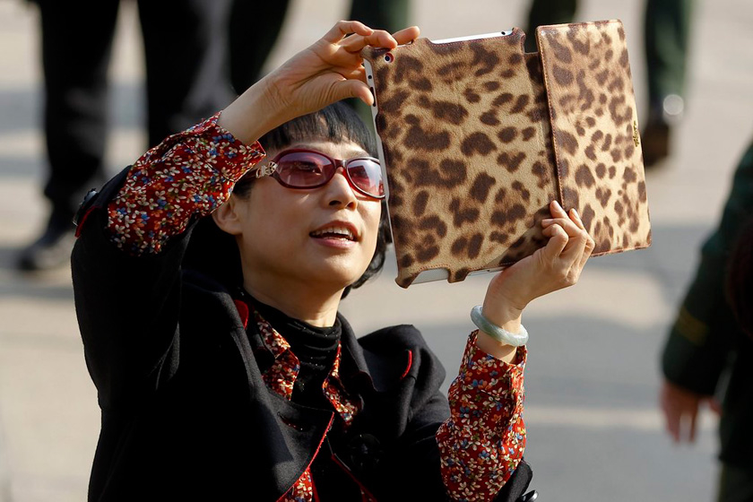 11月8日，北京，一名女代表用平板电脑拍照。  CFP_参加中共十八大的女性代表