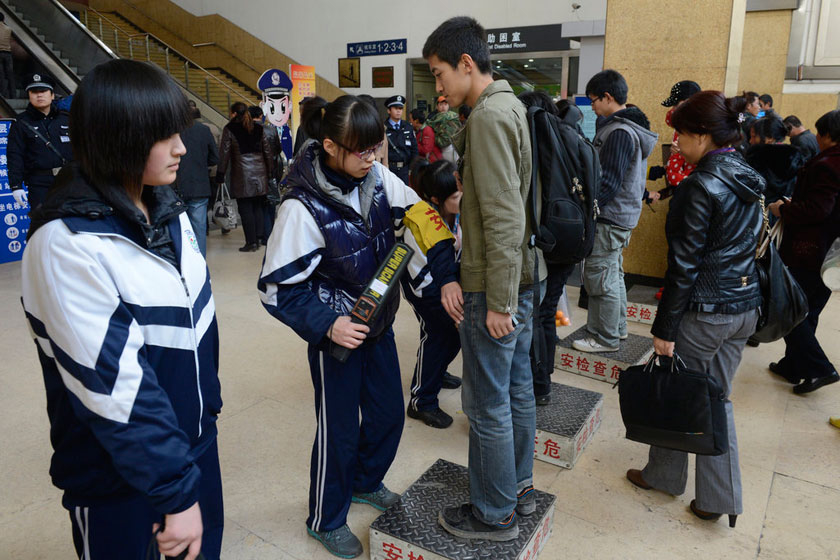 11月08日，太原火车站进站口，身穿校服的安检员正在对入站旅客进行安全检查。    CFP_太原保卫十八大 学生安检员上岗执勤