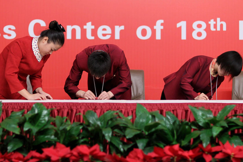 11月10日，北京，十八大新闻中心，工作人员布置台布。    田贺/CFP_十八大服务员布置台布