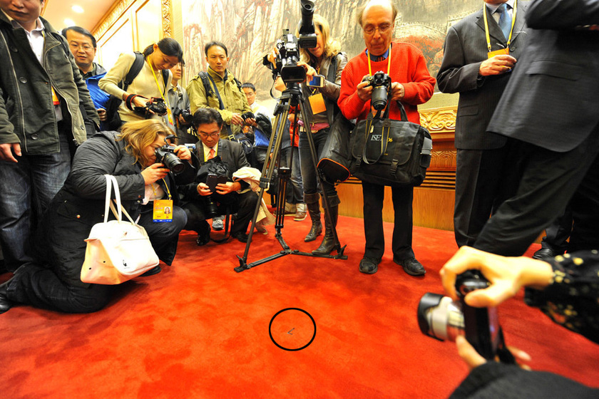 11月15日，记者冲上台前，对着红毯上贴着的常委站立位置的标示拍照。   大可/东方IC_记者围观拍摄常委站立位置标示