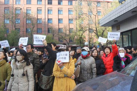 11月29日，京包线沿线小区的数百居民举着标语聚集在北京市规划委。   何林璘/财新实习记者