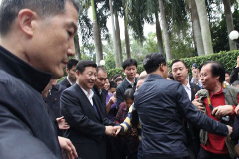12月8日，习近平与民众握手。