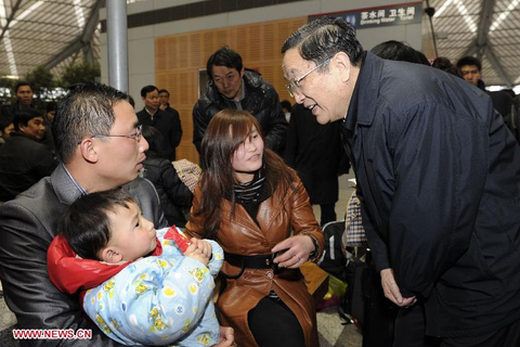 2010年2月11日，中央政治局委员、上海市委书记俞正声在上海火车南站视察春运工作时与旅客交谈。   新华社