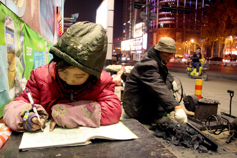 河南小女孩街头卖爆米花 路灯下做作业