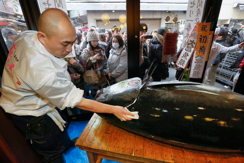 1月5日，日本东京筑地鱼市场拍卖一条巨型金枪鱼，以1.55亿日元（约合180万美元）成交，几乎是先前纪录的三倍。这条金枪鱼重222公斤，在日本北部大间市所属海域捕获。山万为寿司连锁店董事长洁木村（音译）当天拍获这条金枪鱼。图为1月5日，餐厅工作人员处理金枪鱼。   KIMIMASA MAYAMA/CFP