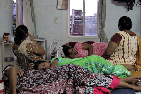 印度已经成为新的世界代孕中心。其代孕妈妈的收费价格比全球平均水平低许多，因此世界各地的不孕夫妇慕名而来，在这里甚至可以节省一半的费用。代孕业务仅在全球少数国家是合法的，根据非官方数据，印度每年从这一产业中获得的收入高达23亿美元。图为2009年9月3日，印度古吉拉特邦，当地一家小诊所内休息的怀孕妇女。   Anna CUNNINGHAM/东方IC