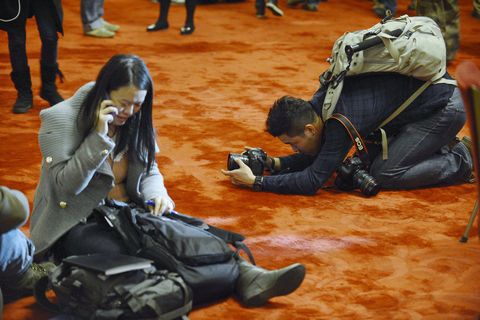 3月4日，北京，记者们或坐或趴在红地毯上忙碌着。    江心/CFP