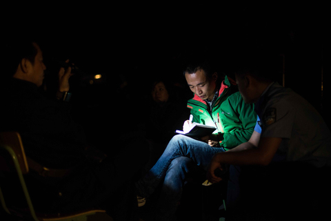 4月22日，四川省雅安市宝兴县灵关镇，记者在安置点内采访，因停电，一人用手电帮忙照明。