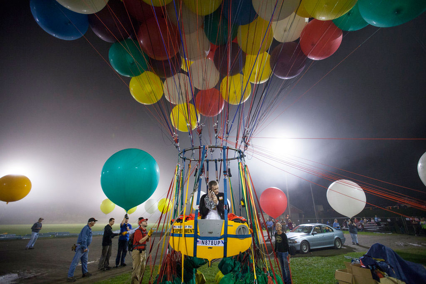 当地时间9月12日，美国缅因州，乔纳森·特拉普乘坐370个大型气球吊起的小艇起飞，准备飞越大西洋。   CFP_美国男子“飞屋环游”挑战飞越大西洋