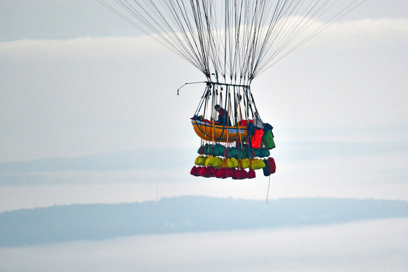 当地时间9月12日，美国缅因州，乔纳森·特拉普乘坐370个大型气球吊起的小艇起飞，准备飞越大西洋。   CFP_美国男子“飞屋环游”挑战飞越大西洋