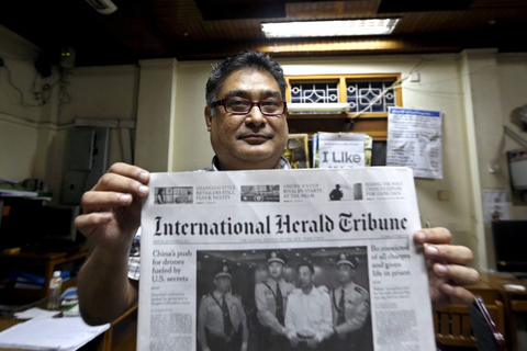 当地时间9月23日，缅甸仰光，工作人员展示《国际先驱论坛报》。该报纸成为了首份在缅甸印制发行的外国报纸。缅甸政府4月30日批准美国《国际先驱论坛报》按原版在缅甸印刷出版发行。这是缅甸首次批准外国英文报纸在缅出版。   NYEIN CHAN NAING/CFP