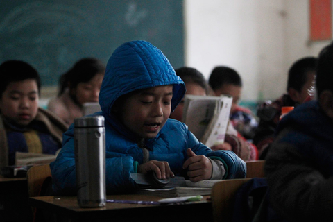 北京昌平区东小口镇芦家村打工子弟学校经纬学校,头戴帽子上课的学生
