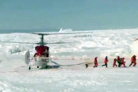 Rescue workers make their way from a helicopter to the Russian ship Akademik Shokalskiy