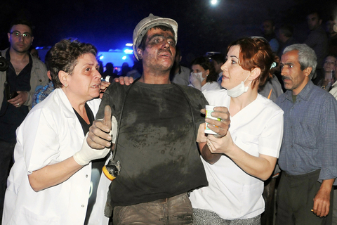 当地时间2014年5月13日，土耳其马尼萨省索玛地区，一个煤矿发生爆炸事故，目前已造成至少157人丧生。图为医护人员帮助一名被救援的矿工。东方IC 