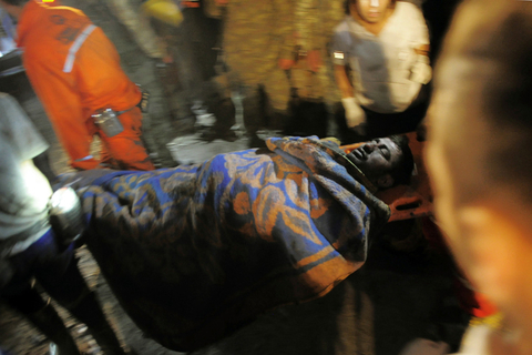 当地时间2014年5月13日，土耳其马尼萨省索玛地区，一个煤矿发生爆炸事故，目前已造成至少157人丧生。图为矿工抬着被救援的伤者。东方IC 