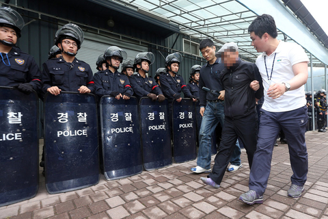 当地时间2014年6月11日，韩国首尔，6000多名警察强行进入首尔附近一个宗教团体内，以搜捕在韩国沉船事故中潜逃的涉事船主俞炳彦。据了解，72岁的船主俞炳彦是一名宗教领袖。警方搜捕时，这个宗教团体的人员在入口处设置了路障，但并未能成功。俞炳彦涉嫌贪污、渎职和逃税漏税，在“世越号”沉船事故发生后，其贪污腐败行为被曝光，此后俞炳彦开始潜逃，至今下落不明。     CFP