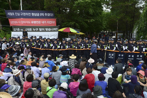 当地时间2014年6月11日，韩国首尔，6000多名警察强行进入首尔附近一个宗教团体内，以搜捕在韩国沉船事故中潜逃的涉事船主俞炳彦。据了解，72岁的船主俞炳彦是一名宗教领袖。警方搜捕时，这个宗教团体的人员在入口处设置了路障，但并未能成功。俞炳彦涉嫌贪污、渎职和逃税漏税，在“世越号”沉船事故发生后，其贪污腐败行为被曝光，此后俞炳彦开始潜逃，至今下落不明。     CFP