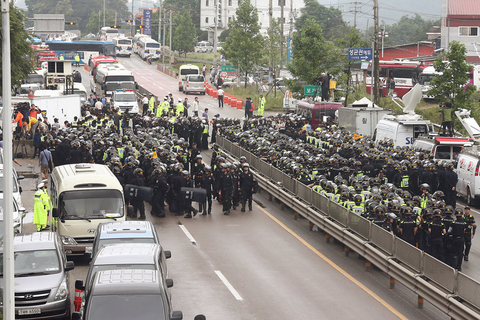 当地时间2014年6月11日，韩国首尔，6000多名警察强行进入首尔附近一个宗教团体内，以搜捕在韩国沉船事故中潜逃的涉事船主俞炳彦。据了解，72岁的船主俞炳彦是一名宗教领袖。警方搜捕时，这个宗教团体的人员在入口处设置了路障，但并未能成功。俞炳彦涉嫌贪污、渎职和逃税漏税，在“世越号”沉船事故发生后，其贪污腐败行为被曝光，此后俞炳彦开始潜逃，至今下落不明。     CFP