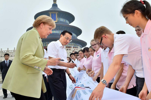 2014年7月7日，北京，李克强总理陪同德国总理默克尔参观了天坛公园，并与近百名出席中德语言年闭幕式的两国青少年交流。两国总理询问了孩子们学习对方语言文化的感受，鼓励他们好好学习，做中德友好的小使者。随后，两国总理参观了祈年殿，并在公园里并肩散步。    图片来源@央视新闻