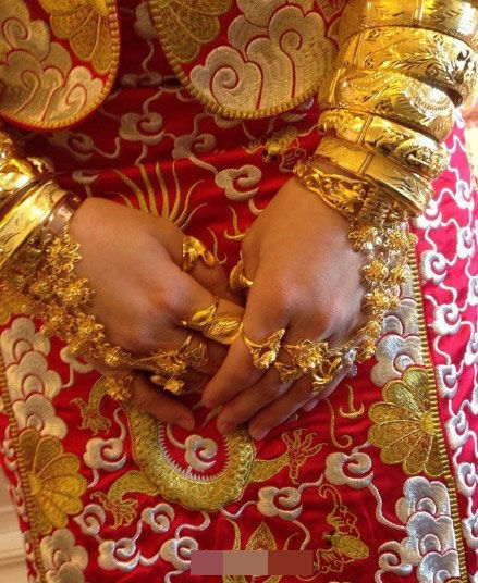 近日网传一组福建泉州新娘的嫁妆图，新娘不仅全身戴满黄金首饰，更传言手臂戴满金手镯是标配。曝光的嫁妆中，千万的别墅、聘金都“闪瞎”不少网友。     图片来源网络