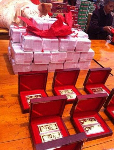 【金条现金炫彩礼】浙江台州的土豪婚礼，十几根金条、亮眼的钻戒以及一捆捆用红绳捆着堆在一起的百元大钞288万现金都摆放在桌子上。     图片来源网络
