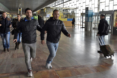 A policeman (L) escorts a family member of an aircrash victim (R) at Barcelona's El Prat airport on March 24