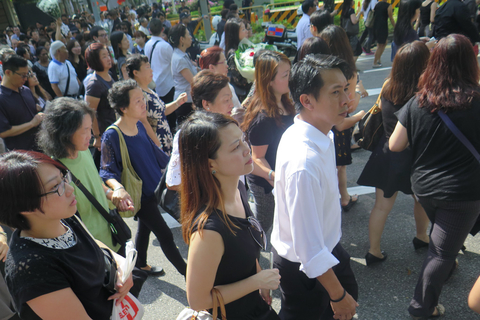 2015年3月25日，新加坡数千民众聚集在市中心路边，目送两天前去世的李光耀灵柩从总统府转至国会大厦。 陈立雄/摄