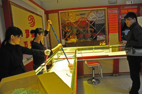 2012年10月29日晚上7时许，江西省南昌市，一蒙面男子一手持枪一手拿着榔头冲入一家老庙黄金首饰店，将柜台的玻璃砸碎后抢走金饰。 CFP