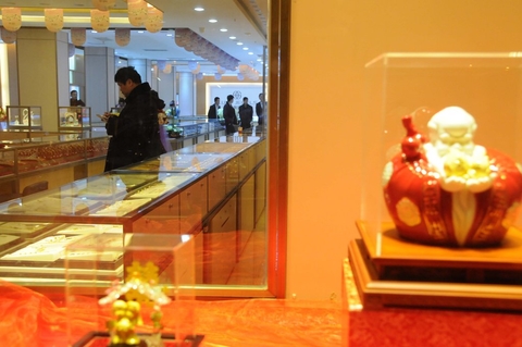 2014年3月8日下午6点左右，广西南宁，一名头戴鸭舌帽的持刀男子在朝阳路一家金店砸开柜台，并抢走价值约29.8万元人民币的黄金，随后逃离。 陈旭运/CFP